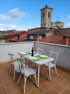 Hotel Rural Envero في Pesquera de Duero: طاولة بيضاء وكراسي تجلس على شرفة