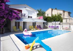 een zwembad met een roze zwaan en een glijbaan bij Resort due gatte Pinky Trogir in Seget Vranjica