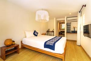 a bedroom with a large white bed and a television at Tan Thanh Garden Homestay in Hoi An +35 photos