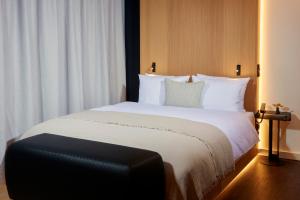 um quarto com uma cama grande e almofadas brancas em HOtello Schwabing em Munique