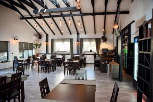 a restaurant with tables and chairs in a room at Casa YDA in Horezu