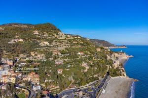 an island with houses on a hill next to the ocean at Casa Castelletto in Finale Ligure