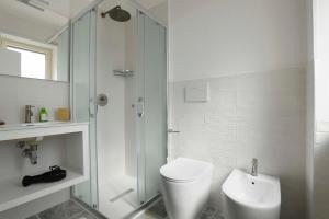 uma casa de banho branca com um chuveiro e um WC. em Lulía bed&breakfast em Otranto