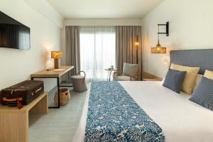 a hotel room with a bed and a desk at Hotel Cabogata Jardín in Retamar