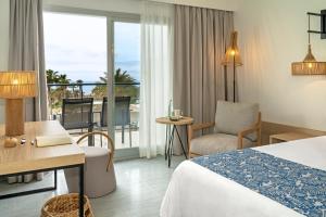 a hotel room with a bed and a balcony at Hotel Cabogata Jardín in Retamar
