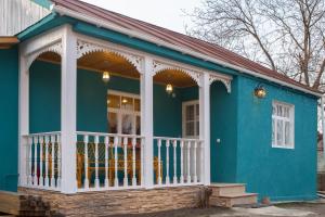 Savanna Guest House في Dedoplis Tskaro: البيت الأزرق مع شرفة بيضاء شاشة