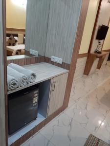 a bathroom with a mirror and a counter with a dishwasher at Hotel Metro Inn in Ajmer