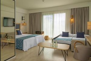 a hotel room with two beds and a table at Hotel Cabogata Jardín in Retamar
