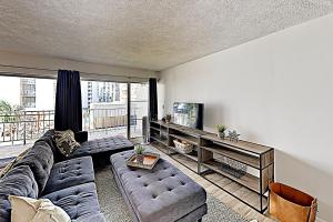 ein Wohnzimmer mit einem Sofa und einem TV in der Unterkunft Hyatt Place 502 in Honolulu