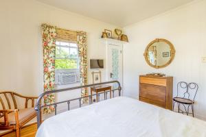 a bedroom with a bed and a mirror and a window at Garden Cottage Unit B in Honolulu