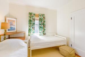 a bedroom with two beds and a window at Garden Cottage Unit B in Honolulu