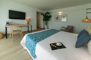 a hotel room with a bed with a tray on it at Hotel Cabogata Jardín in Retamar