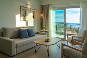 a living room with a couch and a table at Hotel Cabogata Jardín in Retamar