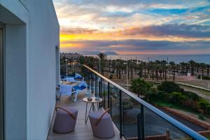 a balcony with tables and chairs and a view of the ocean at Hotel Cabogata Jardín in Retamar