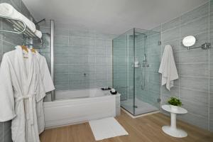a bathroom with a tub and a shower and a sink at Hotel Cabogata Jardín in Retamar