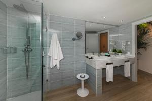 a bathroom with a sink and a glass shower at Hotel Cabogata Jardín in Retamar