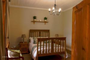 une chambre avec un lit et un lustre dans l'établissement Milky Lane Cottage, à Mooirivier