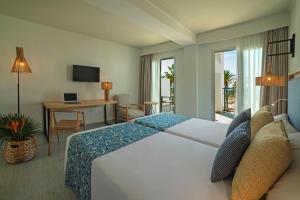a hotel room with a large bed and a desk at Hotel Cabogata Jardín in Retamar