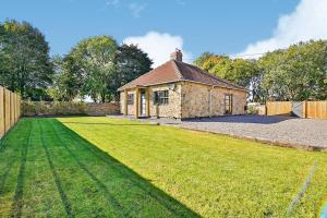 a house with a large lawn in front of it at Dunromin Cottage, Hot Tub & Garden in Coxhoe