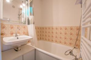 a bathroom with a sink and a bath tub at Studio Ella au cœur du village in Samoëns