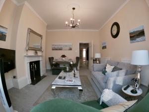 a living room with a couch and a table at Moat Stays Victorian, Sea View! in Kent