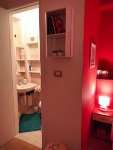 ein Bad mit einem Waschbecken, einem WC und einer roten Wand in der Unterkunft B&B Al Quindici Scilla in Scilla