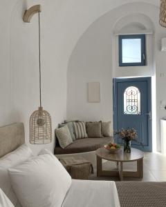 uma sala de estar com um sofá e uma mesa em Arco Bianco Suites em Acrotíri