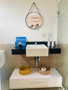 a bathroom with a white sink and a mirror at Beach front apartment in Dream Village Cumbuco, Ceara in Cumbuco