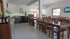 une salle à manger avec des tables et des chaises dans un restaurant dans l'établissement Pousada Tia Ilda, à Pirenópolis