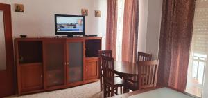 salon z telewizorem, stołem i krzesłami w obiekcie Playa La Caleta CADIZ Barrio La Viña PARKING GRATIS w Kadyksie
