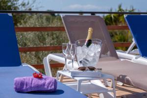einen Tisch mit einer Flasche Wein und Gläser auf einem Stuhl in der Unterkunft Son Vorera, situada en una colina, con piscina. in Es Carritxo