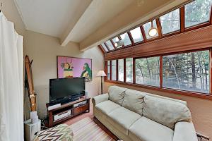 ein Wohnzimmer mit einem Sofa und einem Flachbild-TV in der Unterkunft Predock 1A in Taos Ski Valley