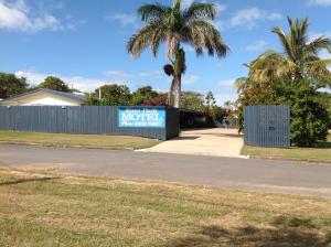 a sign on a fence next to a street at Emu Park Motel in Emu Park