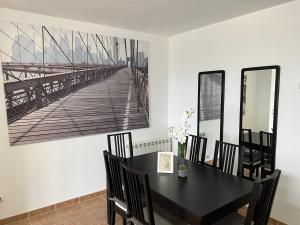 uma sala de jantar com uma mesa preta e cadeiras em Precioso bajo con jardín, junto al campo de Golf em Sojuela