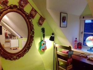 une chambre avec un miroir et une guitare sur le mur dans l'établissement Virginia Cottage, à Bulwick