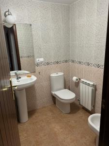 a bathroom with a toilet and a sink and a mirror at Precioso bajo con jardín, junto al campo de Golf in Sojuela