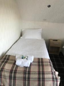 a bed with white sheets and pillows in a room at Gothenburg Hotel in Rosyth
