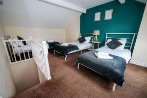 two beds in a room with a green wall at Highfield Lodge in Sheffield