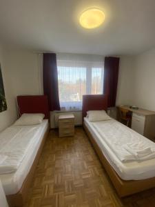 Duas camas num quarto com uma janela em Othman Appartements Hannoversche Straße 23 em Hanôver