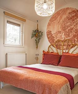 1 dormitorio con 1 cama grande con almohadas rojas en StayatSas Tiny House Sam in de bossen op de Veluwe!, en Epe