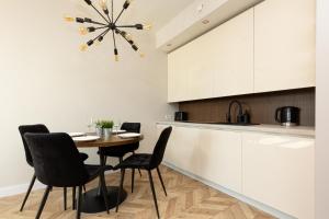 ein Esszimmer mit einem Tisch und Stühlen in einer Küche in der Unterkunft Platinum Towers Apartment with Parking by Renters Prestige in Warschau