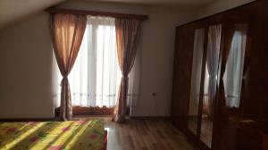 a bedroom with a bed and a large window at Mini Farm Adi in Cazin