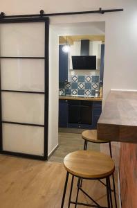 a kitchen with two stools and a sliding door at BRICK Apartment in Žilina