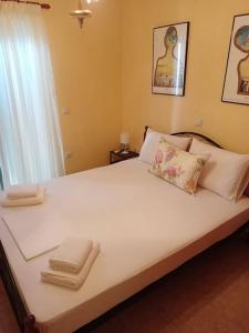 um quarto com uma grande cama branca e uma janela em Alexandra's Apartment em Kalamitsi