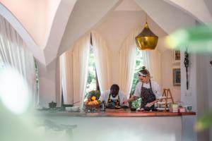 zwei Personen stehen in einer Küche und bereiten Essen zu in der Unterkunft Xanadu Villas & Retreat in Bwejuu