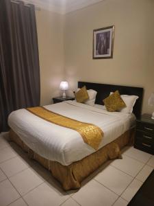 1 dormitorio con 1 cama grande con mantas y almohadas amarillas en Safwt Aldyar Furnished Units, en Abha