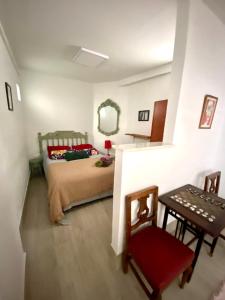 een slaapkamer met een bed, een tafel en een spiegel bij Casa Albaicin 1 in Granada