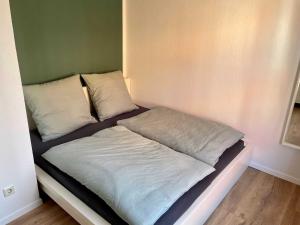 a bed with two pillows on it in a room at Ferienwohnung Hafensicht 25507 in Weener
