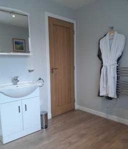 a bathroom with a sink and a mirror and a door at Caisteal Liath in Lochinver