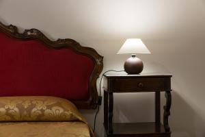 a lamp on a table next to a bed at at 2 minutes from San Marco square in Venice